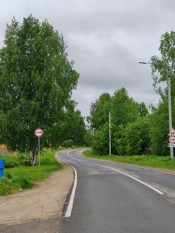 Wet rural road documented in Чухлэм, Russia after rain