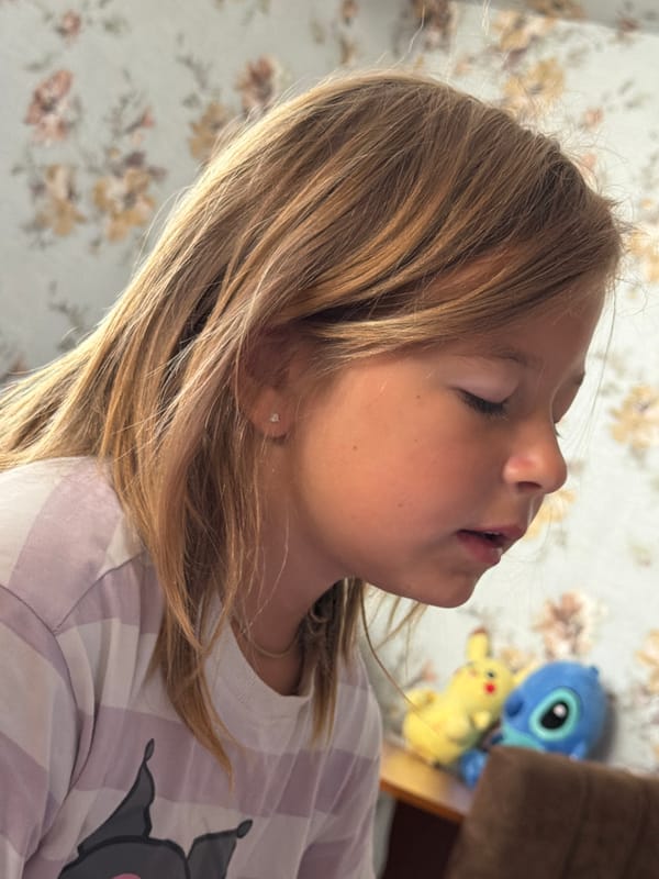 A child and a fluffy white dog at home in Partenit