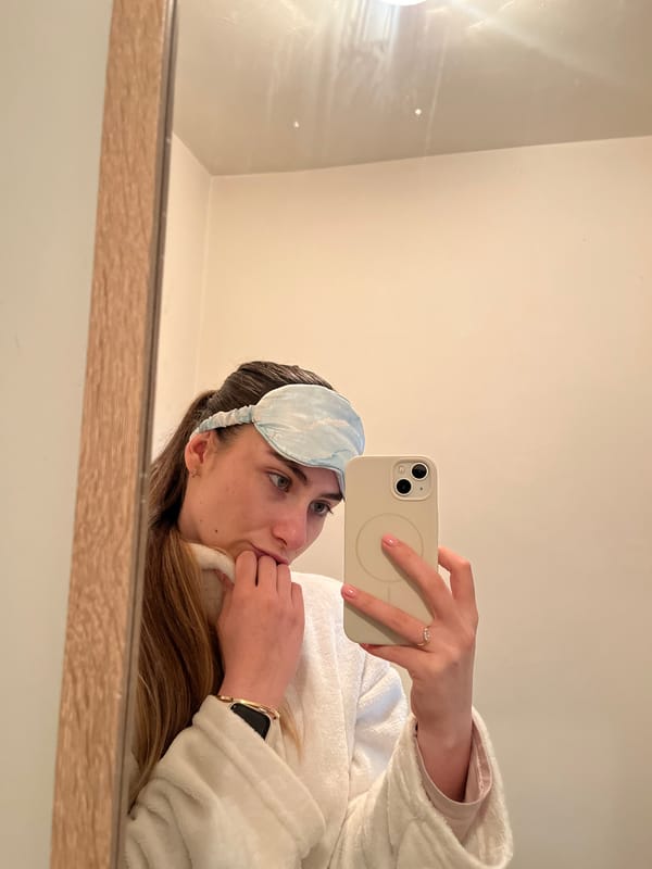 Woman takes bathroom mirror selfies wearing sleep mask and robe