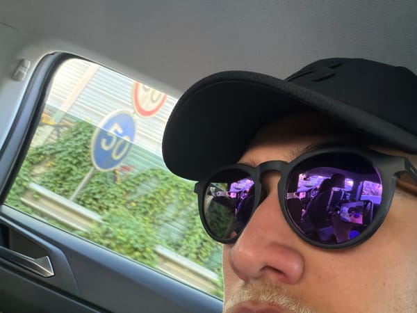 Person in vehicle with arcade lights reflected in sunglasses