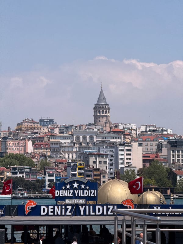 Morning views of Istanbul's Galata Tower captured from water, bridge