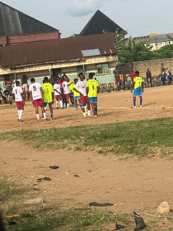 Soccer players gather on dirt field in Umuode, Nigeria