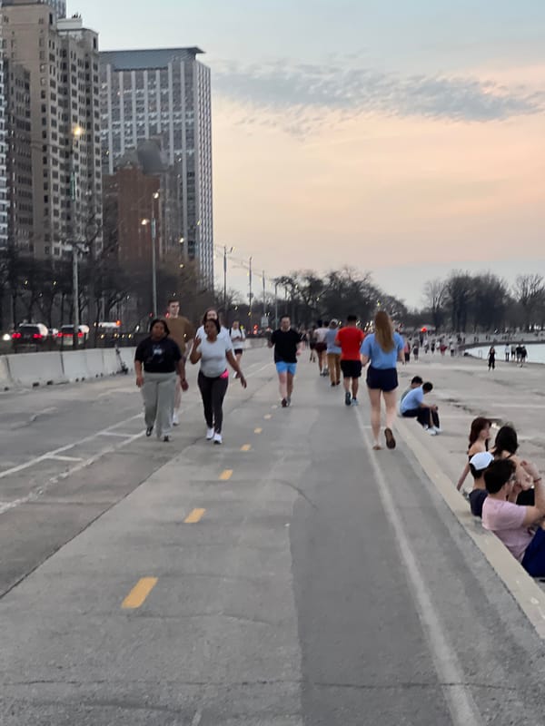 Group walks on Chicago street under overcast sunset sky