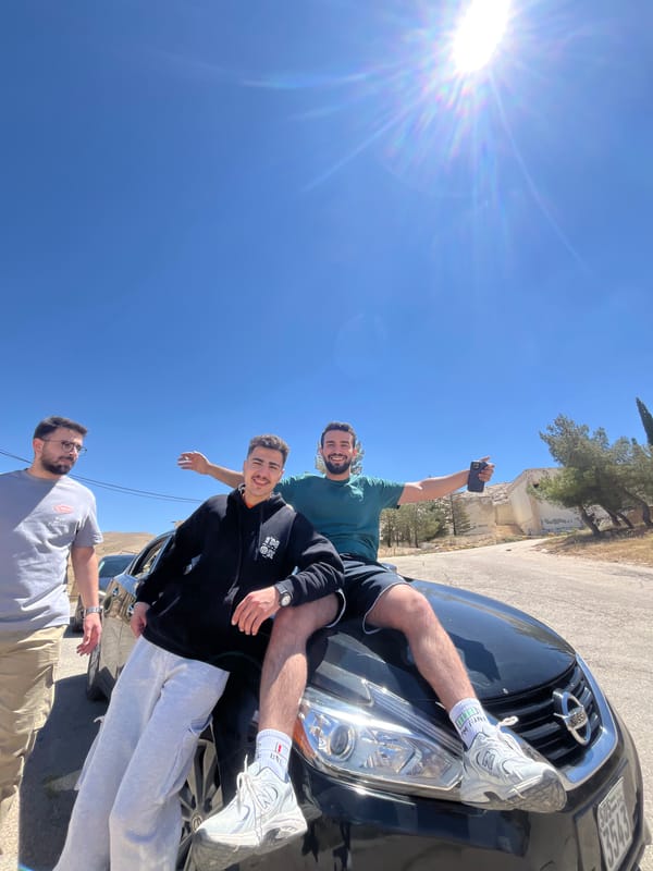 Young men pose with car in Ma'loula, Syria