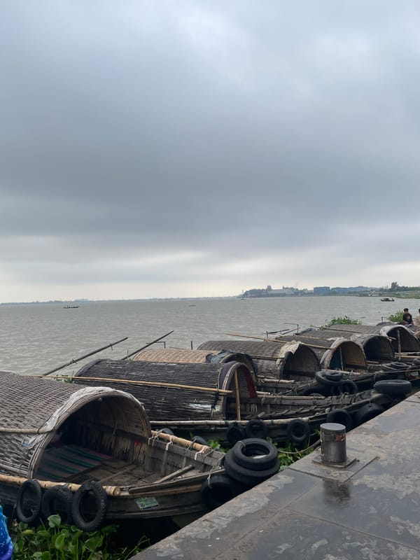 Traditional passenger boats docked at Sonargaon waterfront during cloudy night