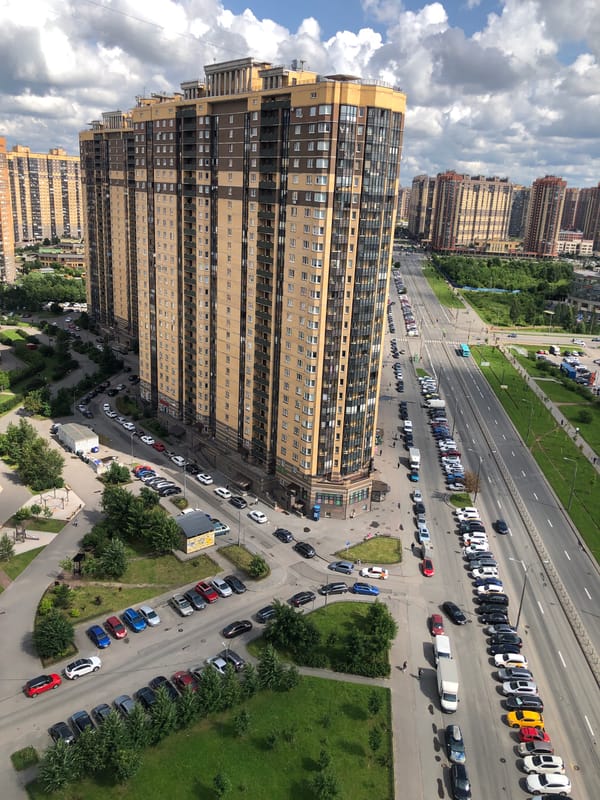 Aerial sweep of a dense apartment district, plus one window cat