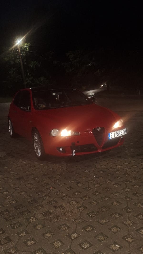Parked car and shop window at night, July 2026