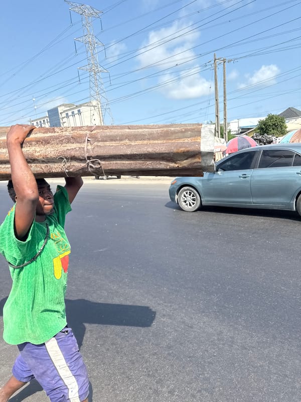 Man carries metal sheet in Igboefon, Nigeria