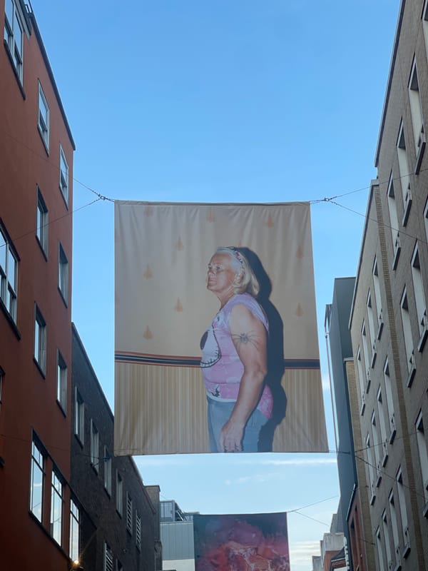 Large portrait banner with spider tattoo displayed in London