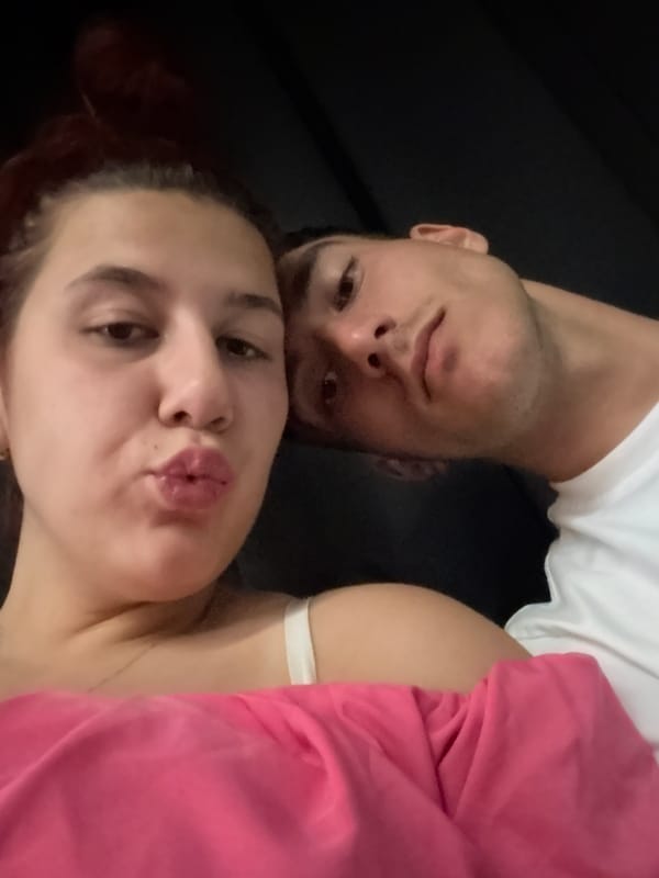 Couple photographed in dimly lit concrete lounge space