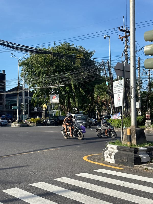 Couple documents motorcycle ride through busy Denpasar streets