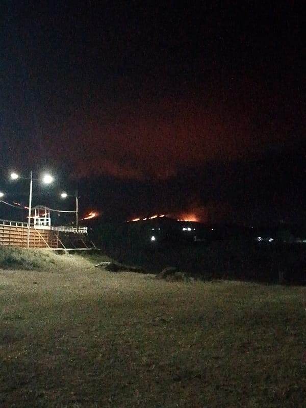 Hillside fire burns as crowd gathers at night event