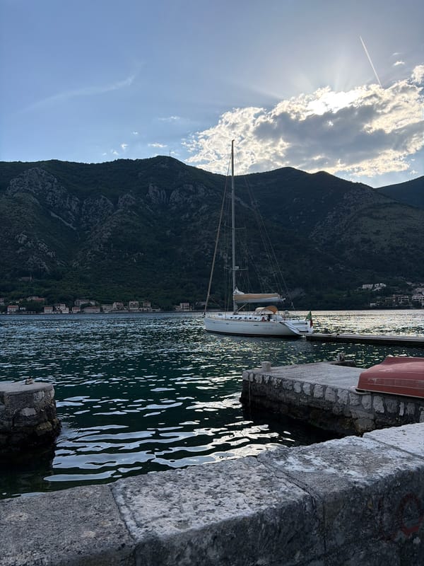 Boats dock at stone pier in Dobrota, Montenegro