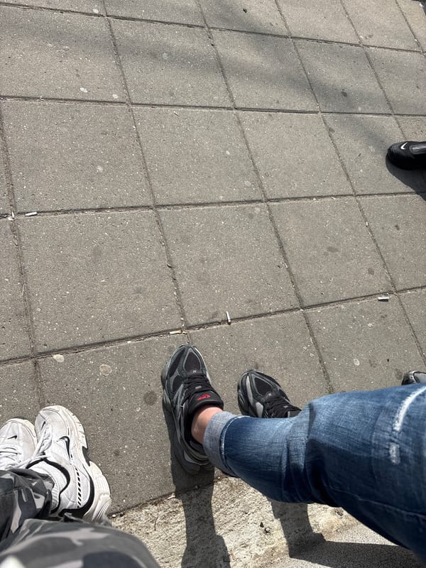 Three people's feet photographed on concrete pavement in Bulgaria