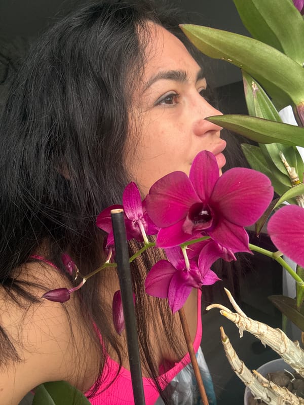 Woman enjoys pizza among orchids in Russian home