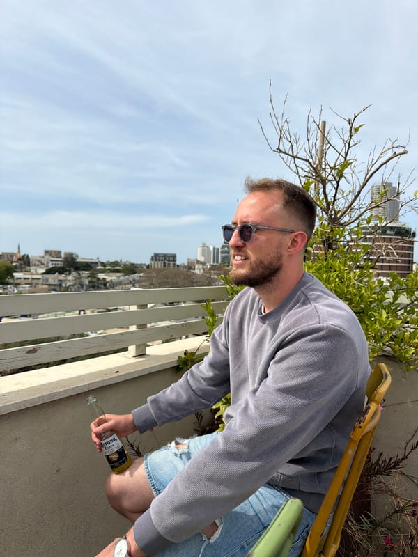 Man smiles on Tel Aviv rooftop during sunny afternoon