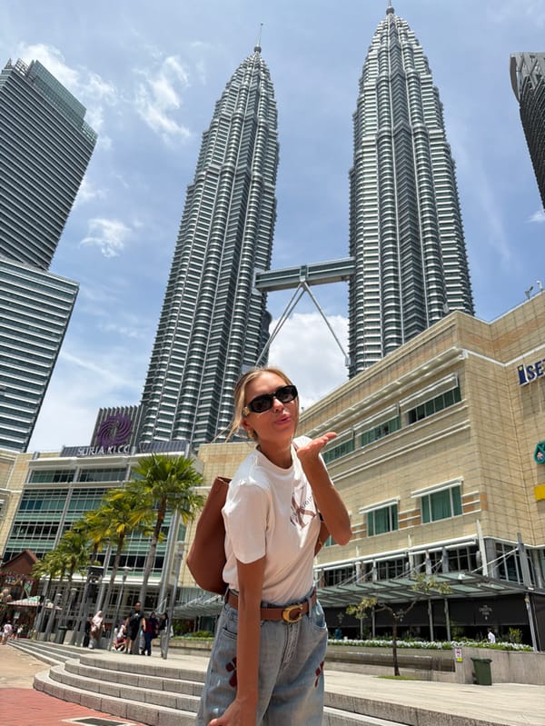 Woman poses for photo at Petronas Twin Towers pedestrian area