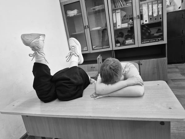 Boy photographed resting on desk in Chaikovsky, Russia