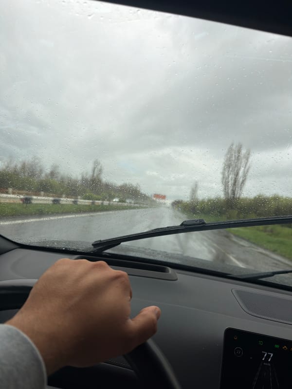 Driver travels past hilltop monastery during morning rain