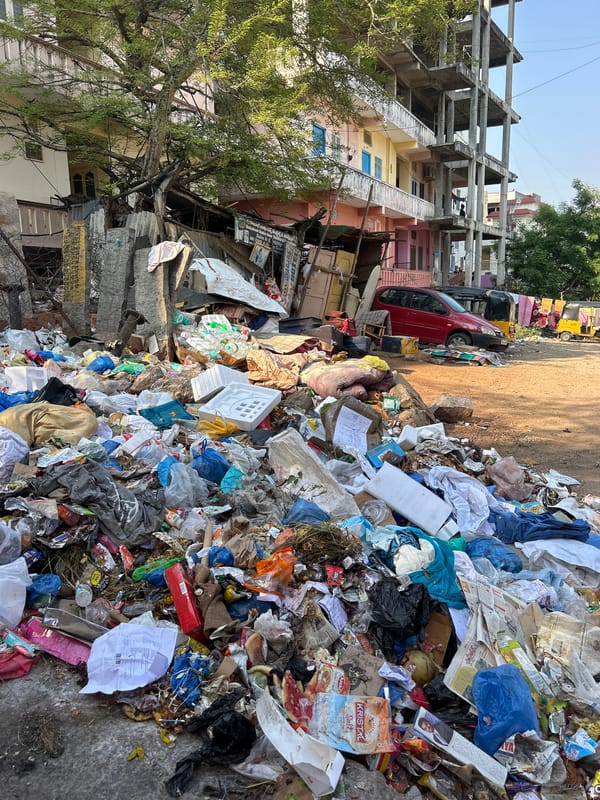 Person relaxes on Puttaparthi balcony with colorful pedicure, citrus water