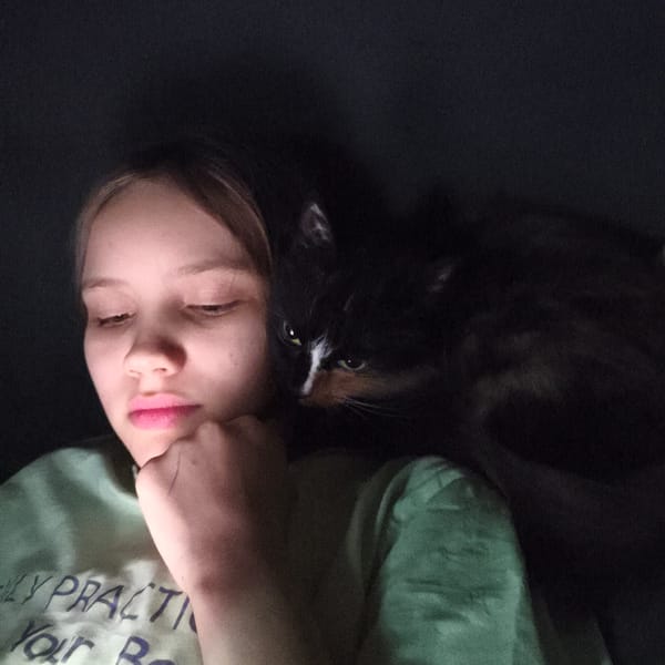 Woman photographed with cat in indoor low-light setting