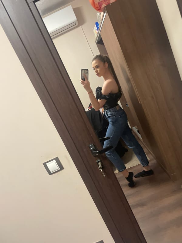 Woman takes mirror selfie in wood-paneled room
