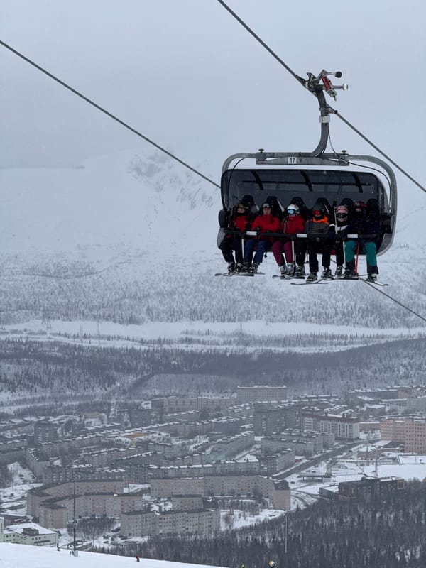 Skiers ride chairlifts up snowy slopes in Kirovsk