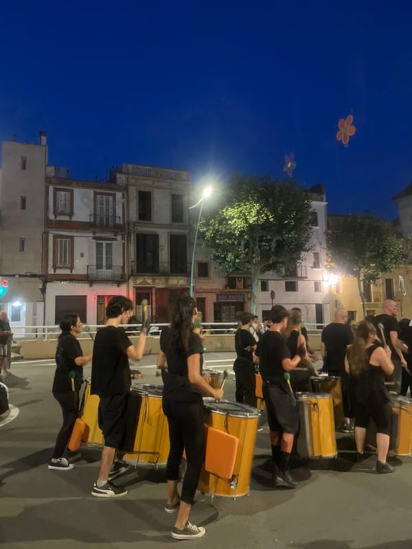Drum parade rolls through Arenys de Mar streets at dusk