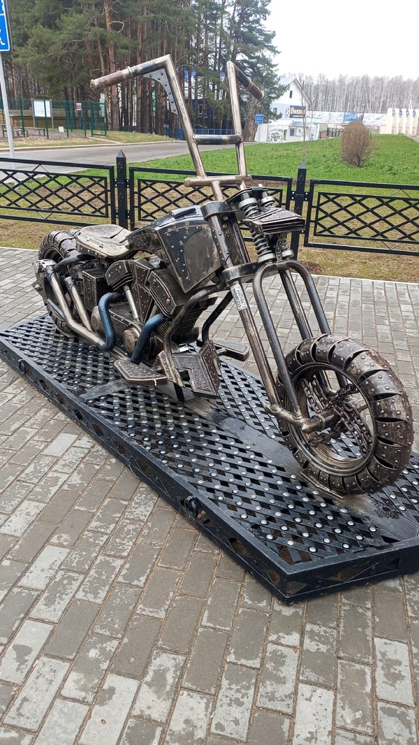 Metal motorcycle sculpture and outdoor gym documented in Chaikovsky