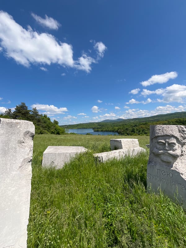 Three men tour historical stone sculptures in Bulgarian countryside