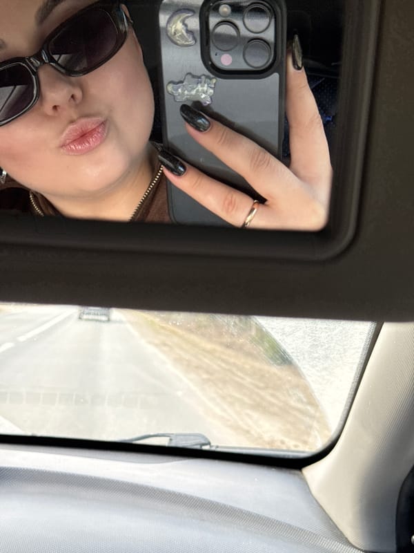 Woman takes reflective selfie in vehicle in Забегалово, Russia
