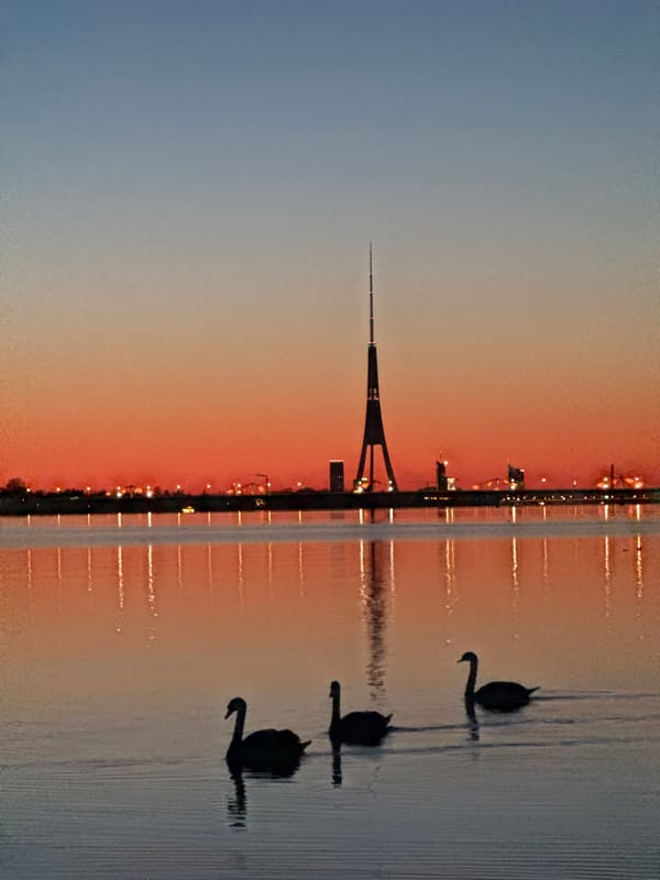 Sunset silhouette of Riga TV Tower captured across Daugava River