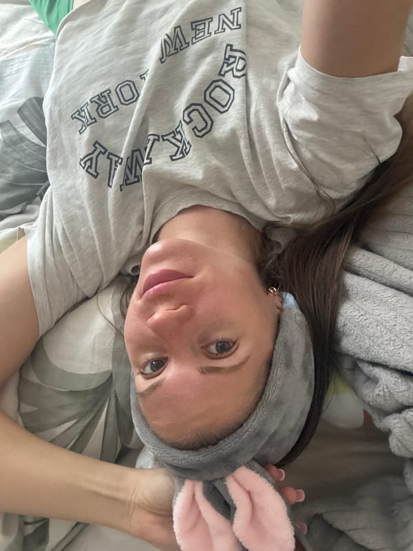 Woman in bunny ears rests in bed in Batumi