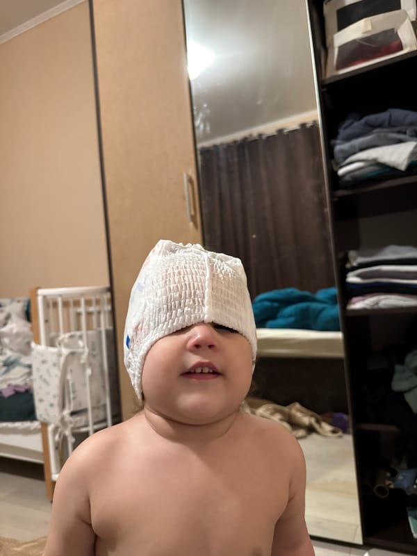 Child plays with diaper on head in Tobolsk bedroom