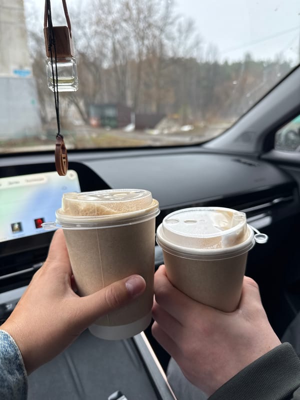 Two people share morning coffee inside vehicle