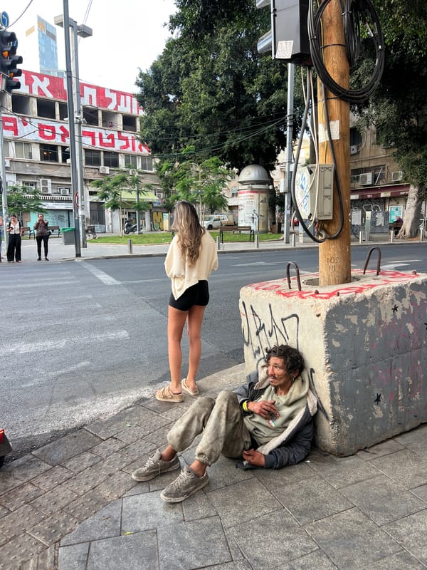 Man rests on Tel-Aviv sidewalk during afternoon hours