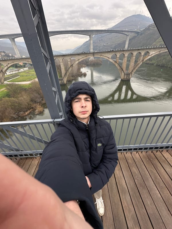 Young man photographs himself on historic bridge in Portugal