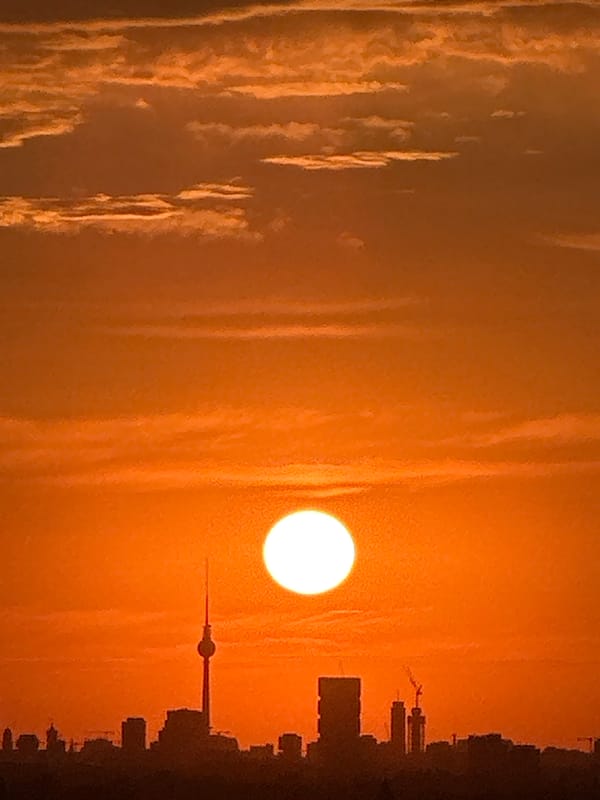 Berlin skyline glows orange as the sun sets low
