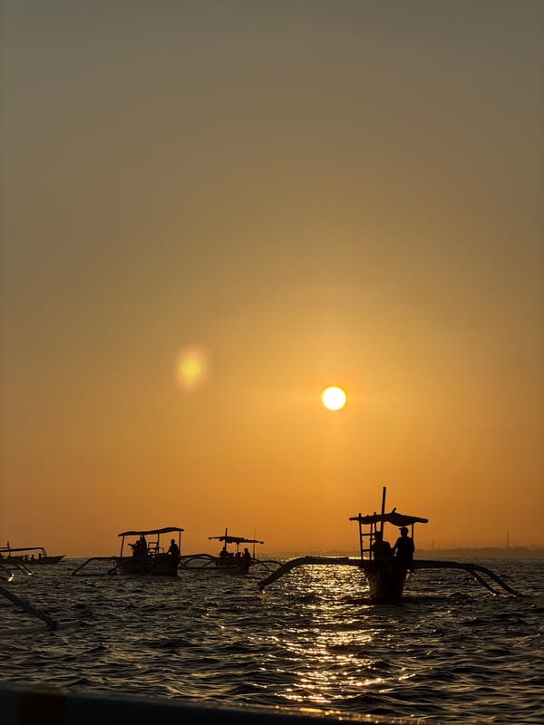 Outrigger boats silhouetted at sunset off Buleleng, Bali