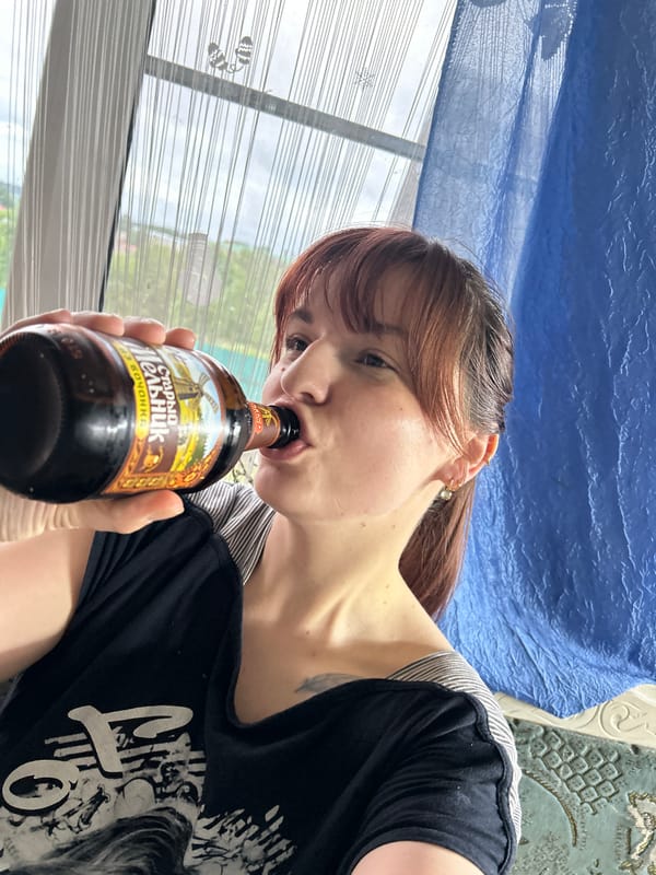 Woman drinks Russian dark beer indoors in Фоки