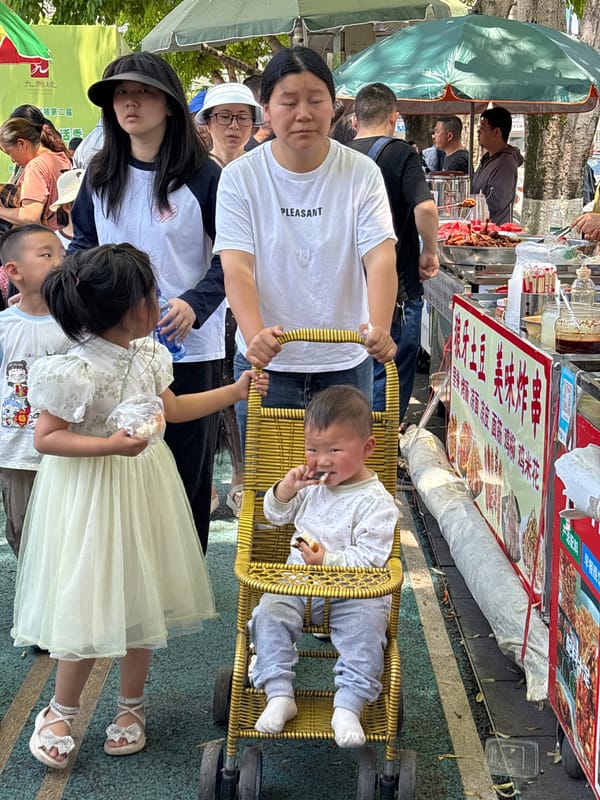 Family gathers outdoors in Jiulongpo District, baby feeds in chair