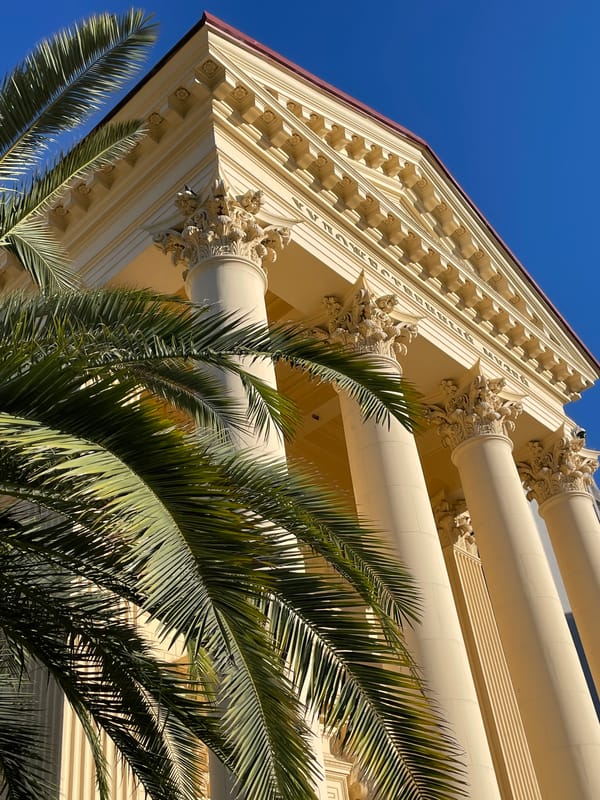 Sochi's Winter Theatre and a nearby café on a sunny afternoon