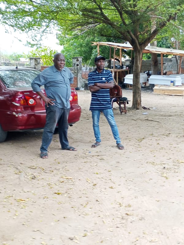 Two men observed standing outdoors in Lokoja, Nigeria