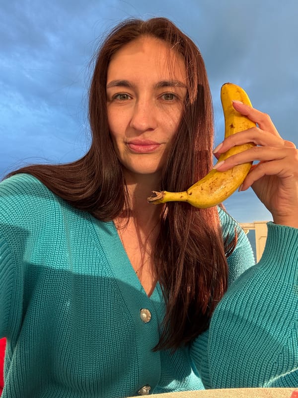 Woman poses with banana on seaside patio in Sochi