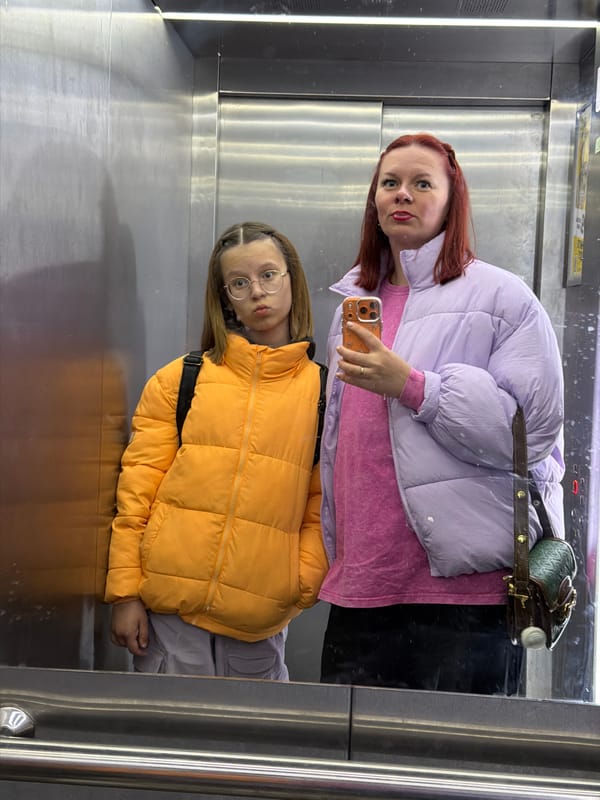 Two women spotted in mirrored elevator reflection