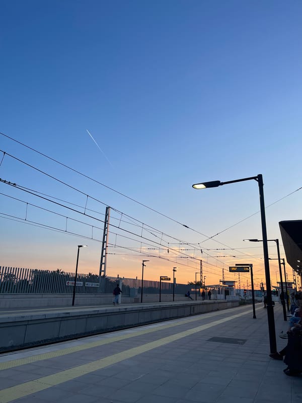 Morning commuter walks Paiporta metro platform at sunrise
