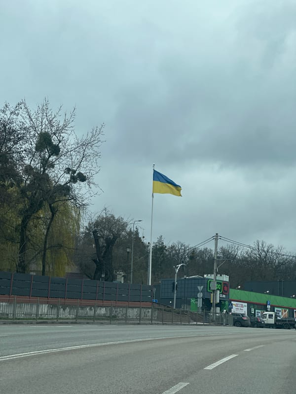 Ukrainian flag flies near damaged buildings in Ukraine
