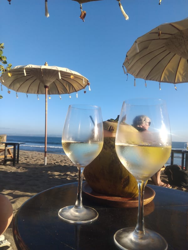 Beach gathering with wine and sandals captured morning