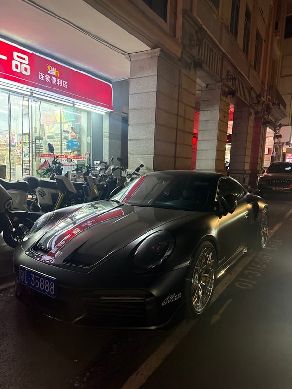 Sports car parked among scooters on Yuexiu District street
