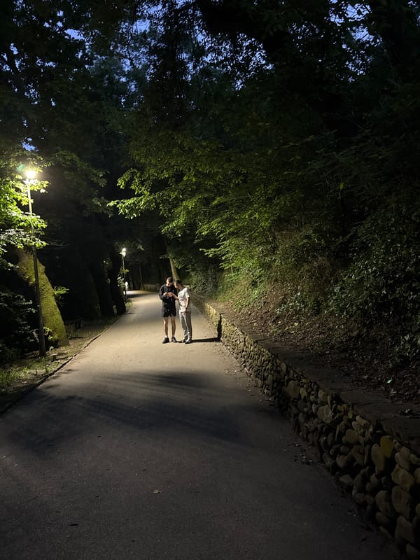 Two people stand on illuminated street in Lovech, Bulgaria